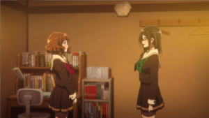 田中あすかの部屋の机棚に六法全書が置いてあるシーン